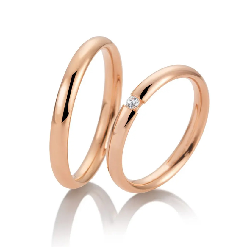 Zwei Ringe aus Roségold, einer davon mit einem kleinen Diamanten besetzt, elegant auf weißem Grund - perfekt für moderne Brautkleider in Stuttgart oder als Inspiration für den Brautstil in der Schweiz.