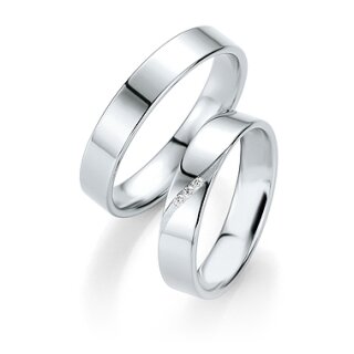 Zwei silberne Eheringe, einer davon mit kleinen Diamanten besetzt, überlappend auf weißem Grund - perfekt für Paare in Stuttgart oder der Schweiz, die elegante Ringe als Ergänzung zu modernen Brautkleidern suchen.